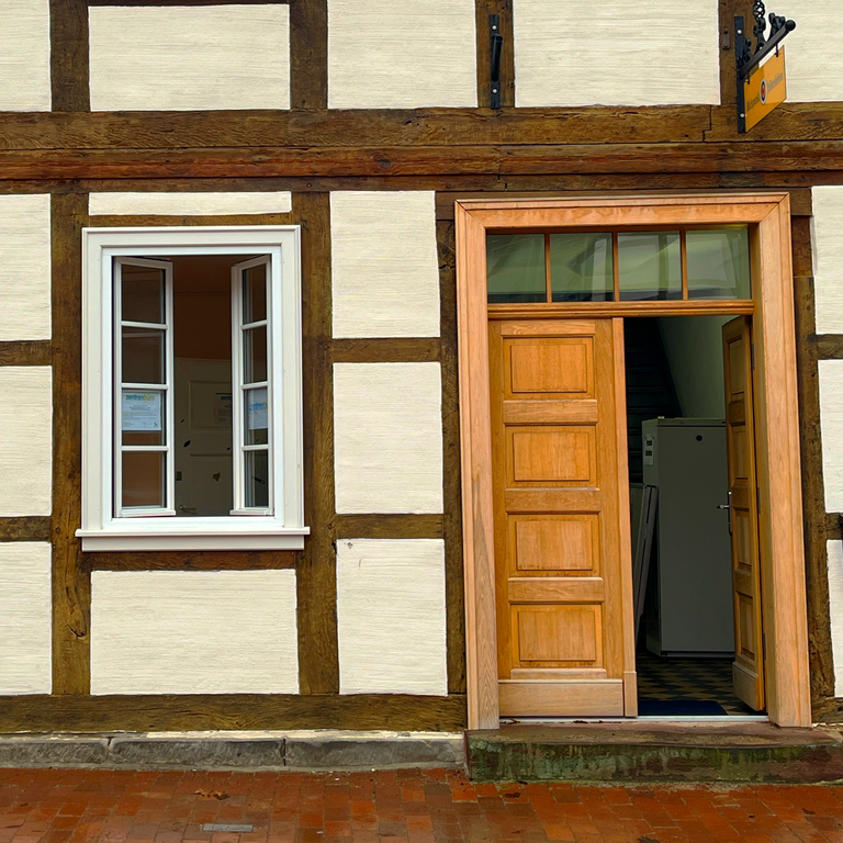 Fachwerkhaus des Zentrebüros am Denkmalplatz. Die Eingangstür steht offen.